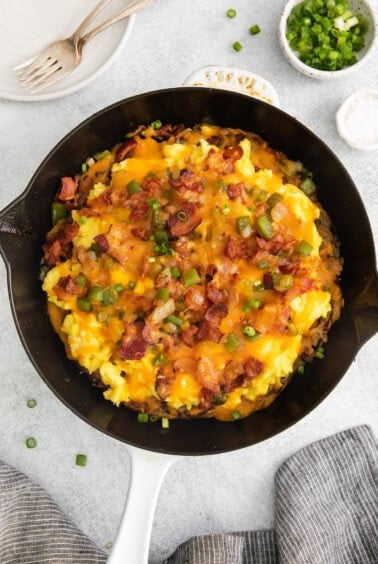 a skillet filled with eggs, bacon and cheese.