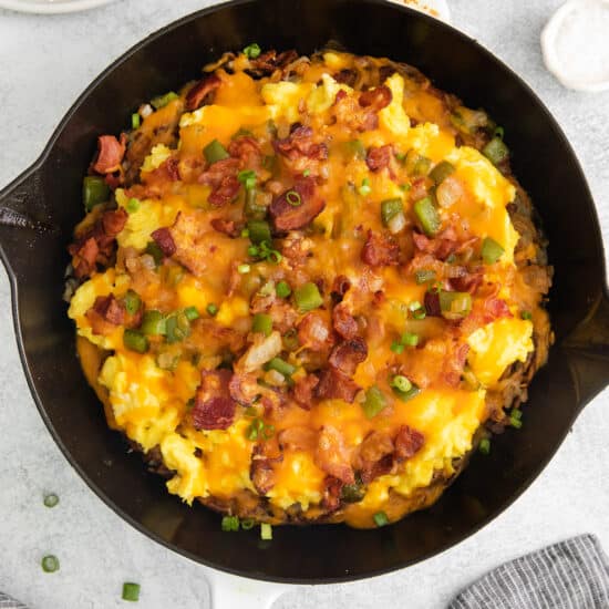 a skillet filled with eggs, bacon and cheese.