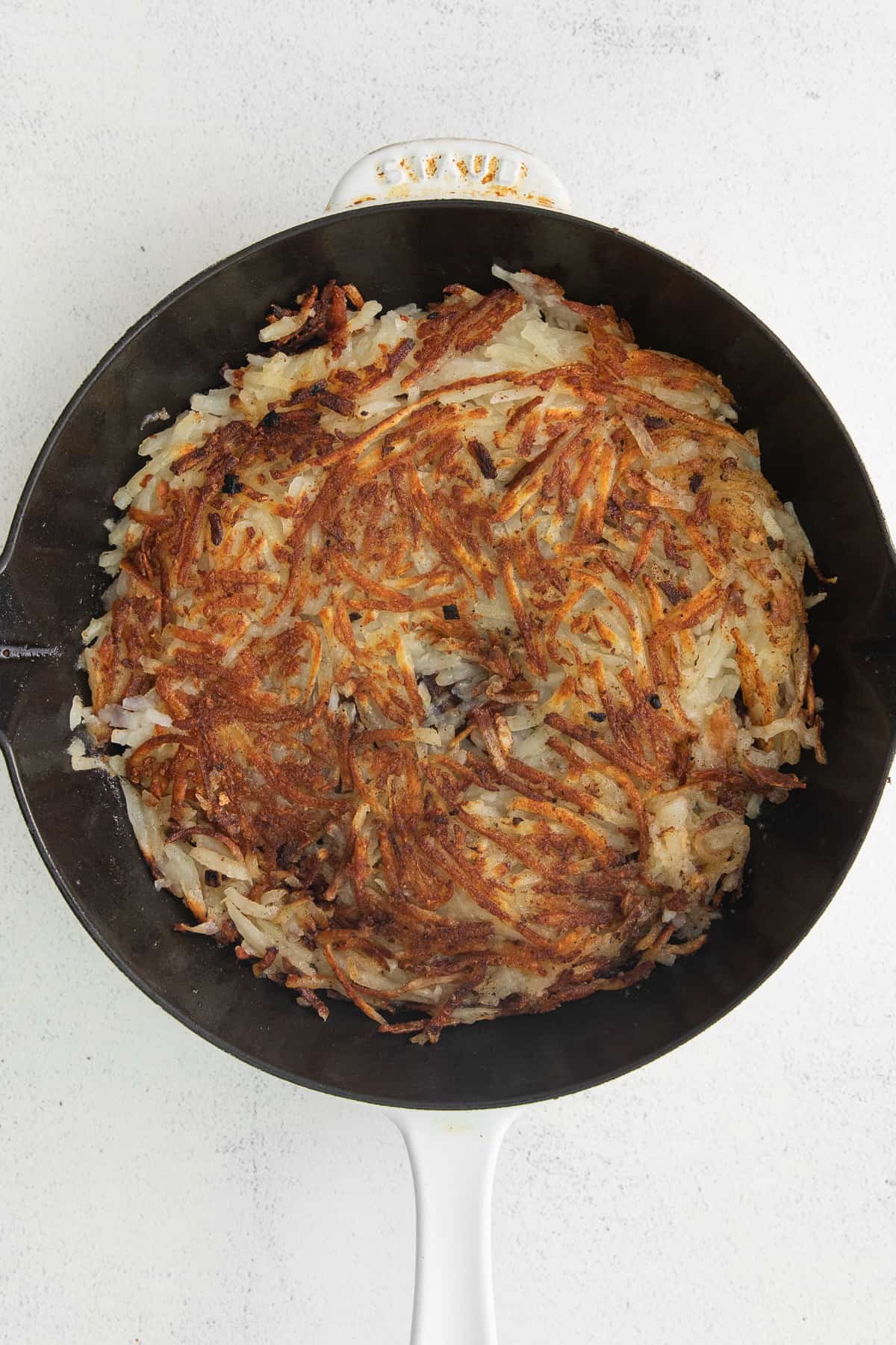 Hash browns in a cast iron skillet.