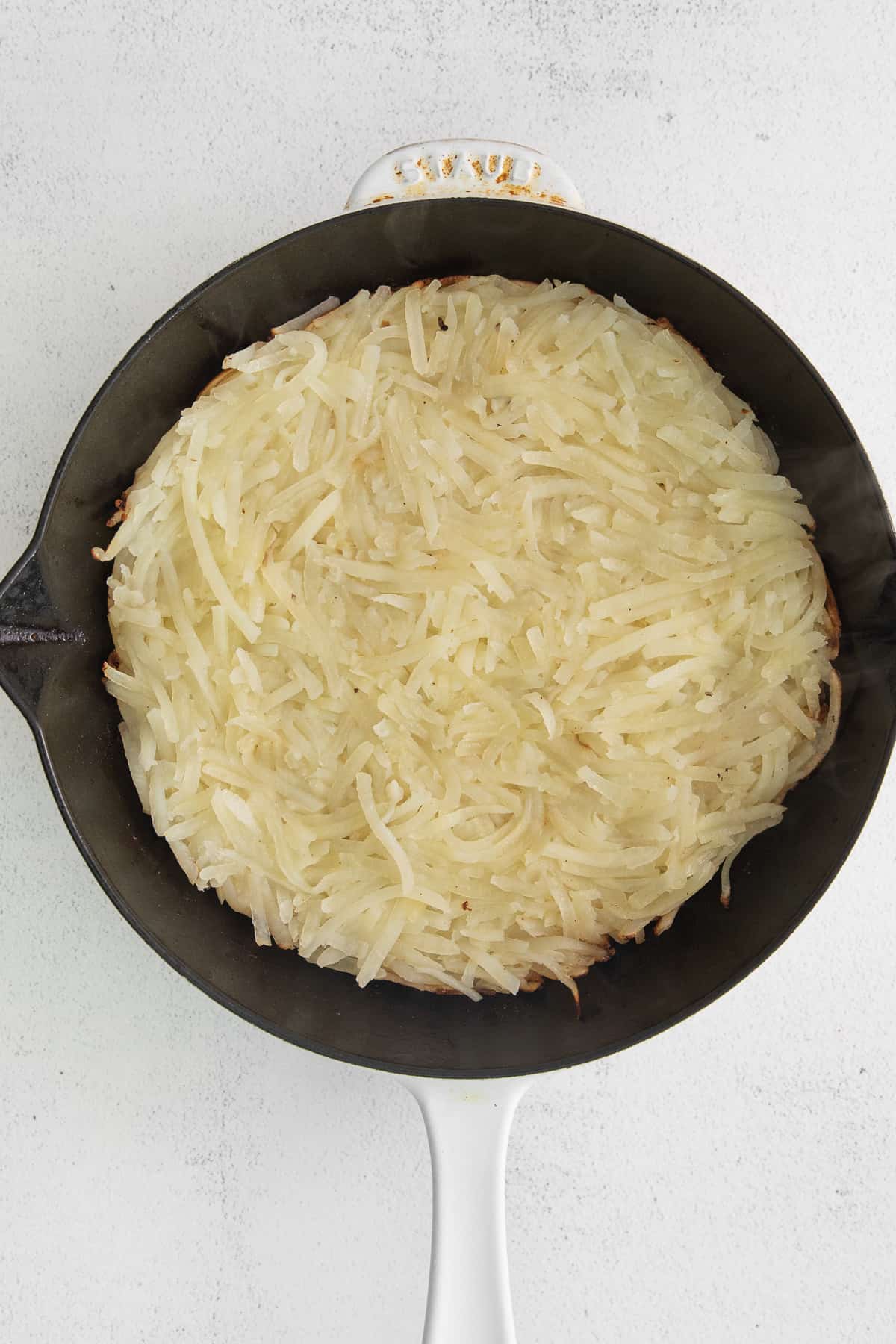 Hash browns in a cast iron skillet.