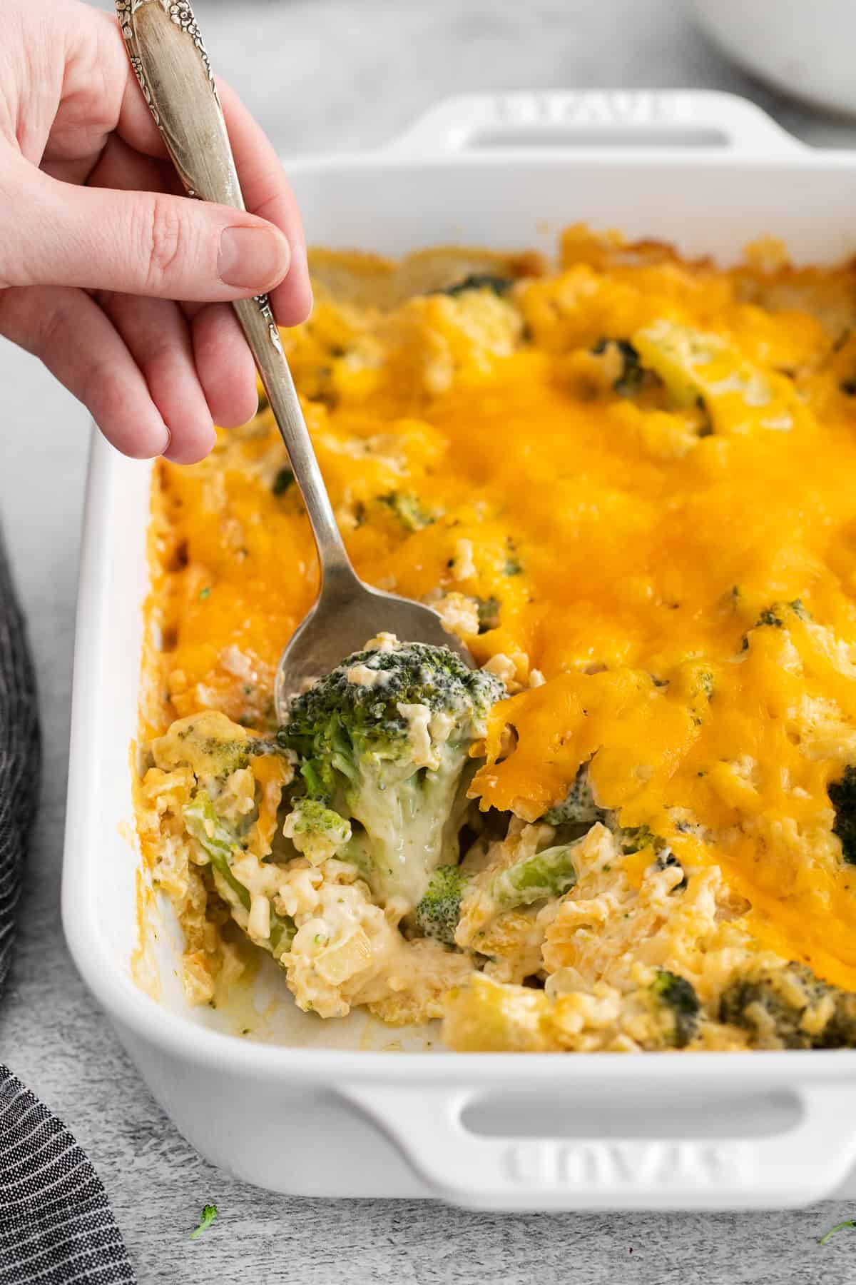 Scoop of broccoli cheese casserole on a spoon.