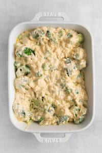 a casserole dish filled with broccoli and cheese.