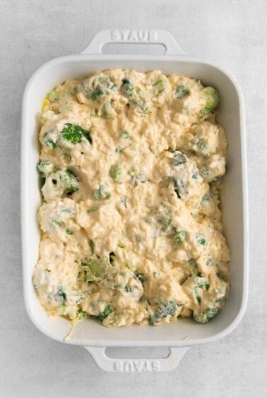 a casserole dish filled with broccoli and cheese.