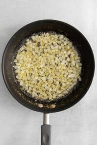 fried onions in a frying pan on a white background.