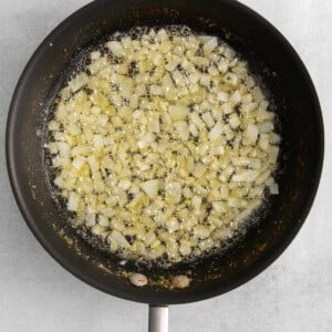 fried onions in a frying pan on a white background.