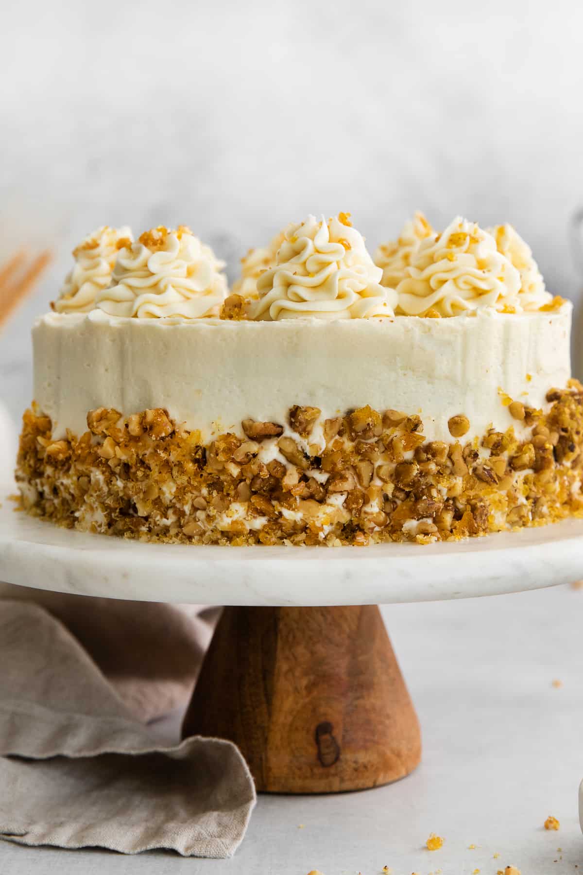 Carrot cake with toasted walnuts on a cake plate.