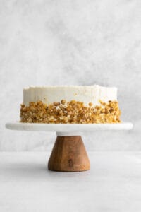 a white cake on a wooden stand.