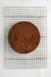 a cake sitting on a cooling rack.