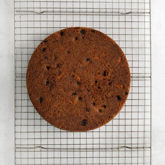 a cake sitting on a cooling rack.