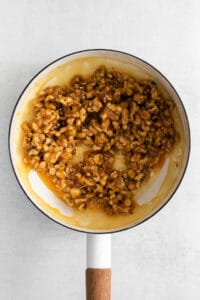 walnuts in a frying pan on a white background.