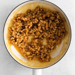 walnuts in a frying pan on a white background.