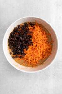 carrots and raisins in a white bowl.