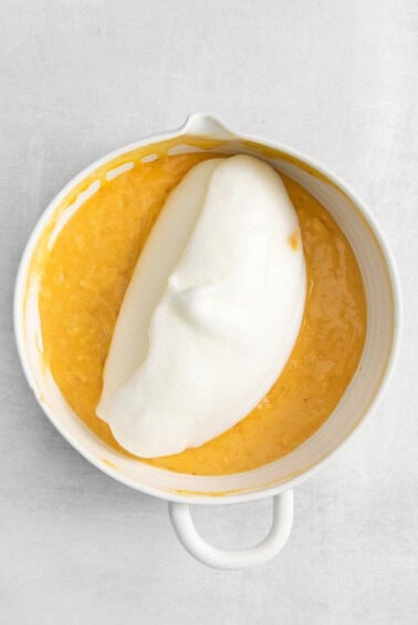 a white bowl with a scoop of ice cream in it.