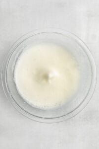 milk in a glass bowl on a white background.