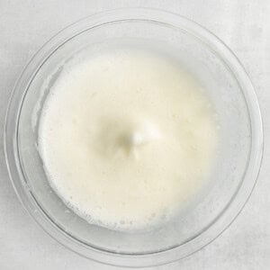 milk in a glass bowl on a white background.