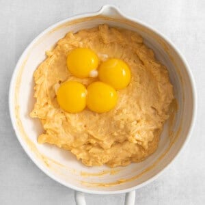 three eggs in a white bowl on a white background.