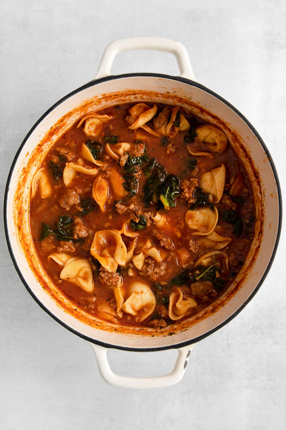 Cheese tortellini soup in a dutch oven.