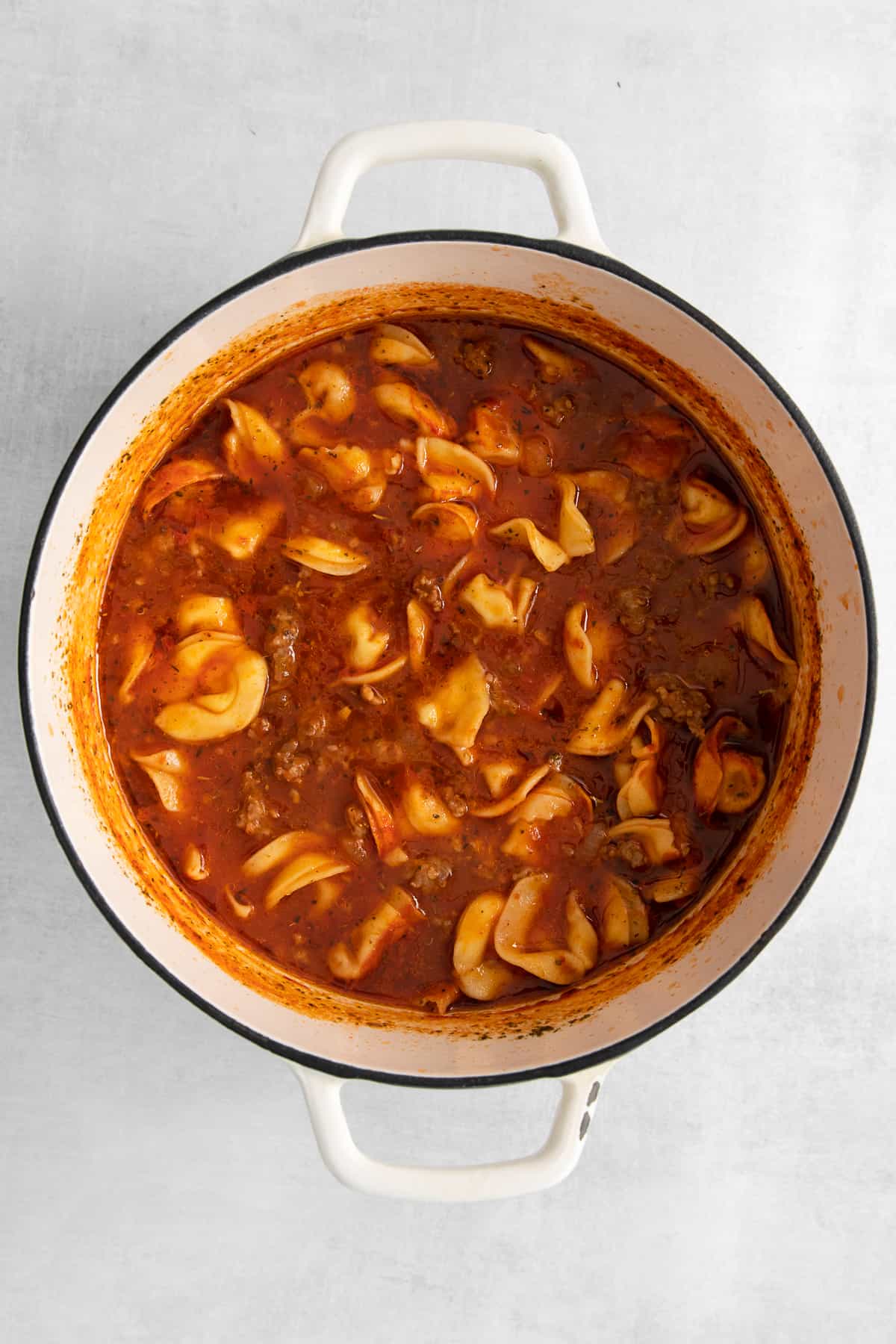 Cheese tortellini soup in a pot.