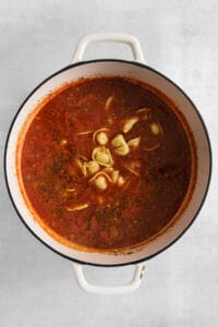 a pot of tomato soup with noodles in it.