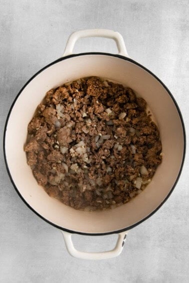 a pot filled with ground beef and onions.