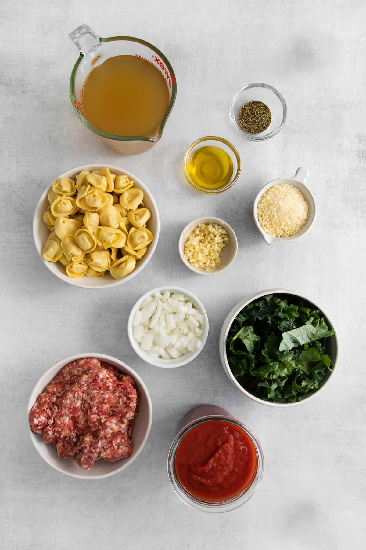 Cheese tortellini soup ingredients in bowls.