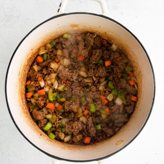 beef stew in a pot on a white background.