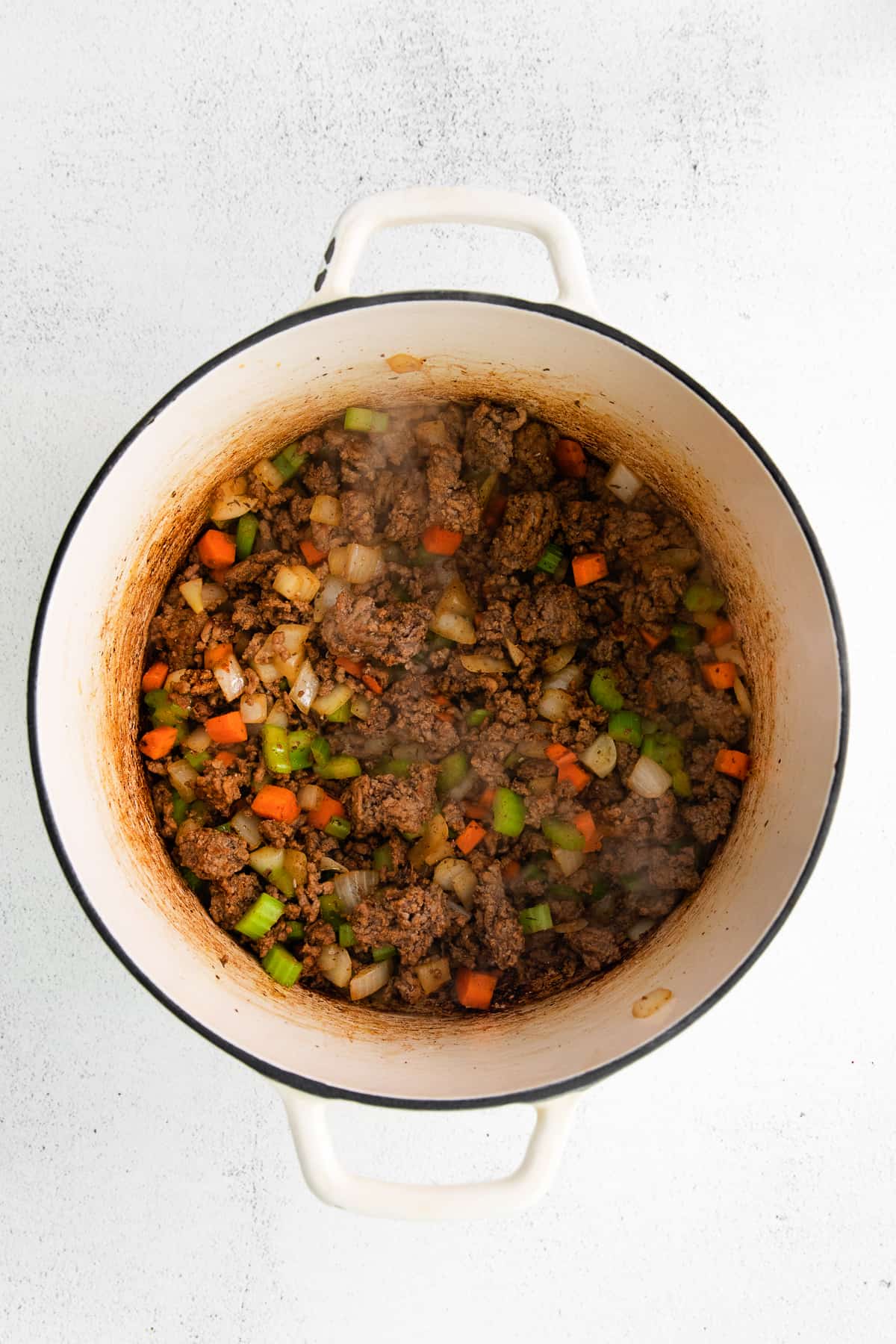 Sautéed ground beef in a dutch oven with veggies.