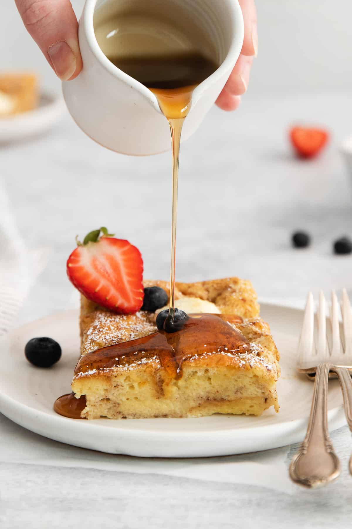 pouring maple syrup onto French toast.