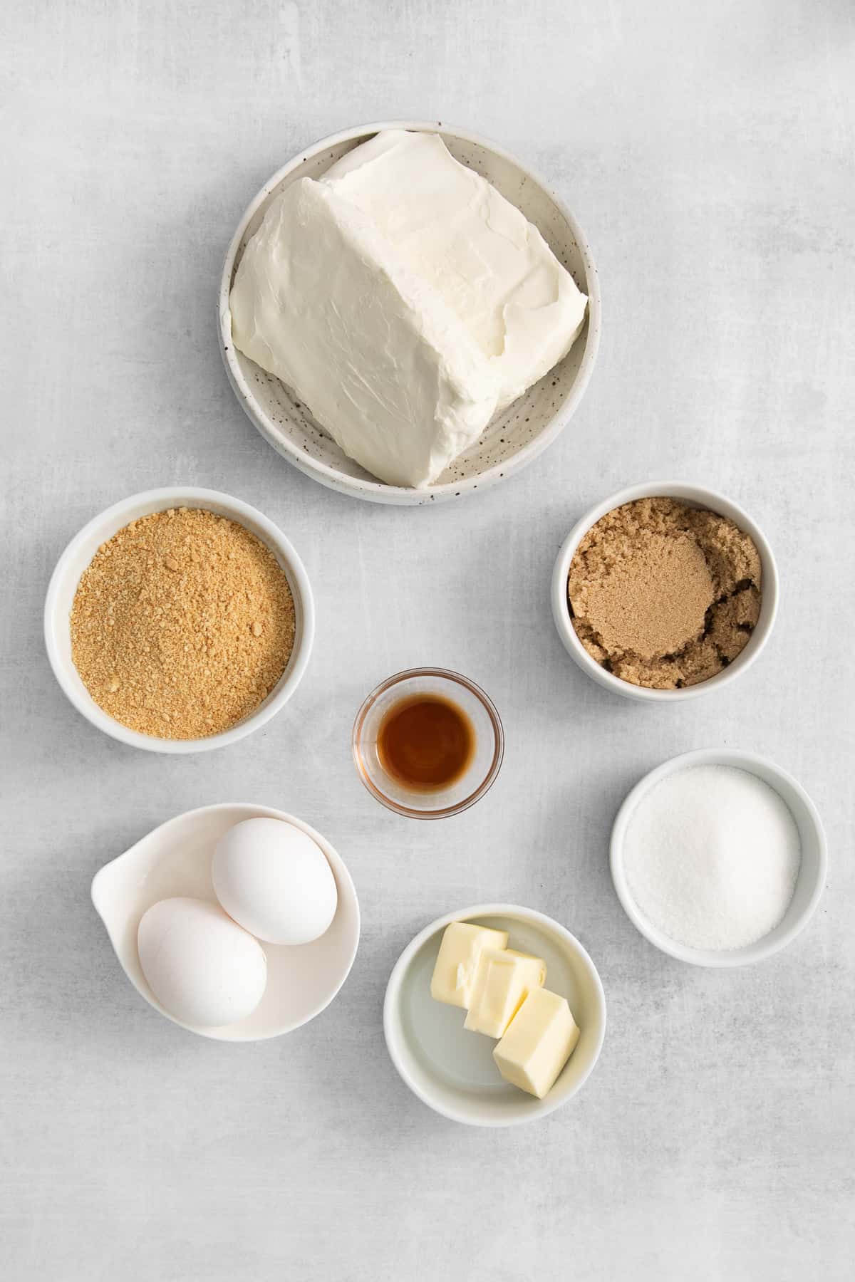 Ingredients for mini cheesecakes in small bowls. 