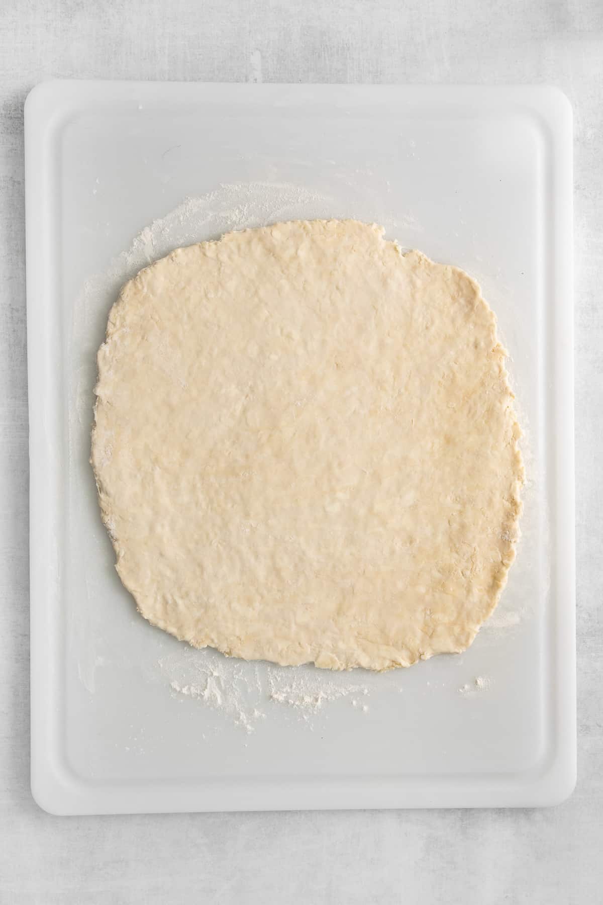 Homemade puff pastry dough rolled out on a cutting board.