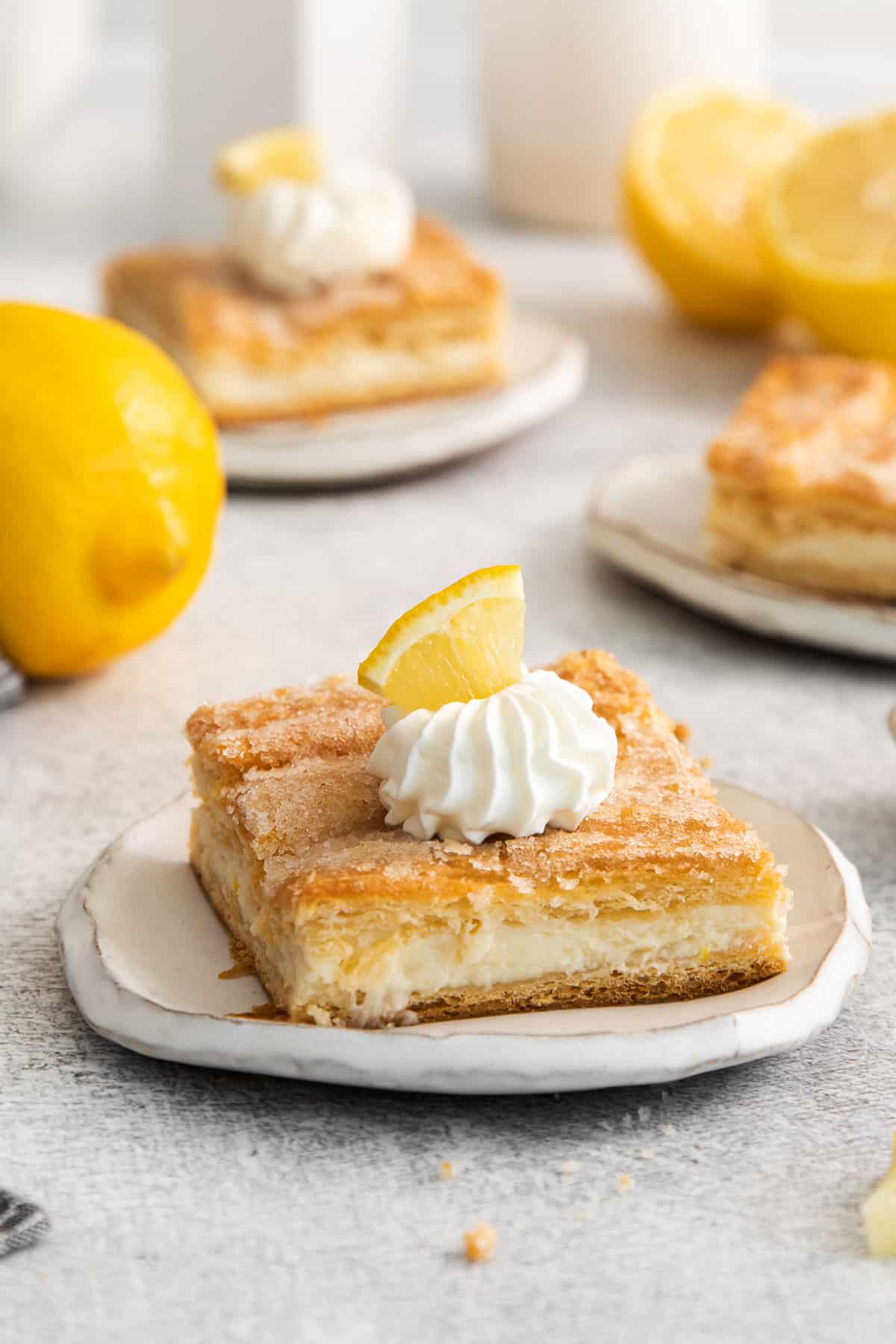 Lemon cream cheese bar on a plate with whipped cream.