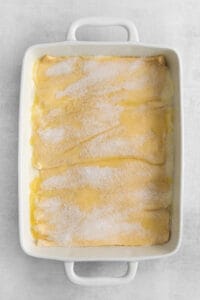a white baking dish with a lemon cake in it.