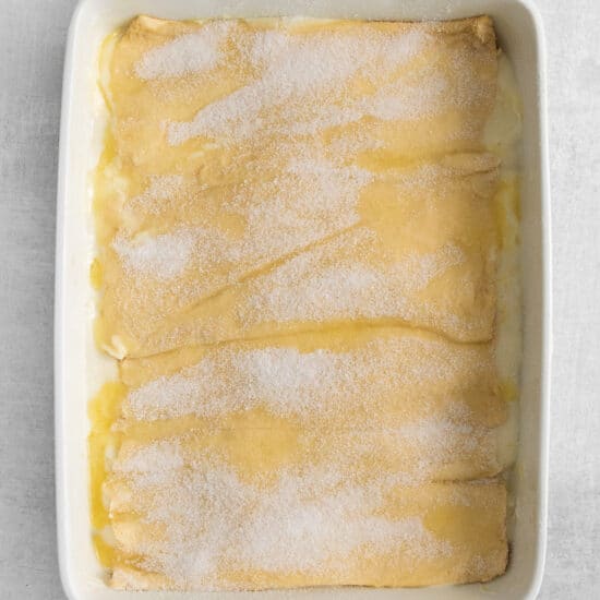a white baking dish with a lemon cake in it.