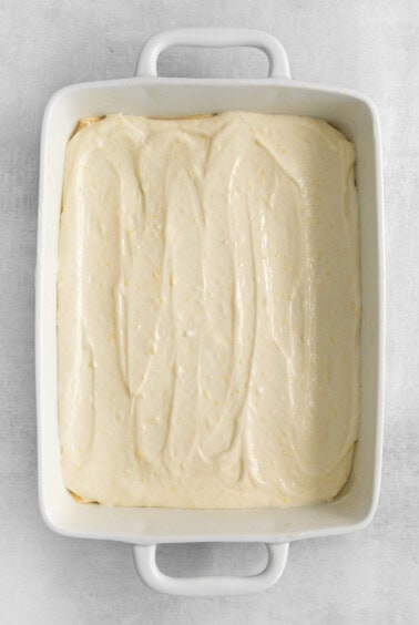 a white baking dish with a layer of icing.