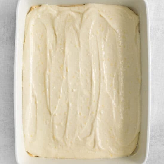 a white baking dish with a layer of icing.