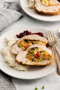 a plate of turkey stuffed with vegetables and mashed potatoes.