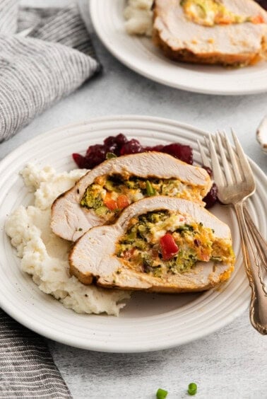 a plate of turkey stuffed with vegetables and mashed potatoes.
