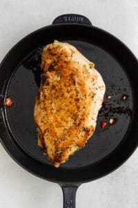 a chicken breast in a cast iron skillet.