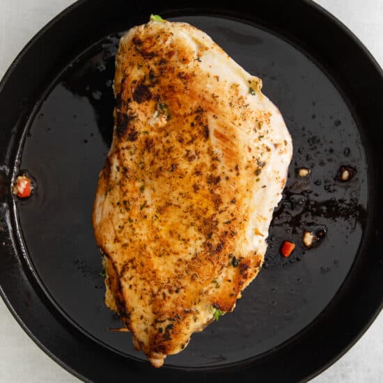 a chicken breast in a cast iron skillet.