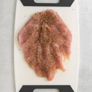 a cutting board with a piece of meat on it.