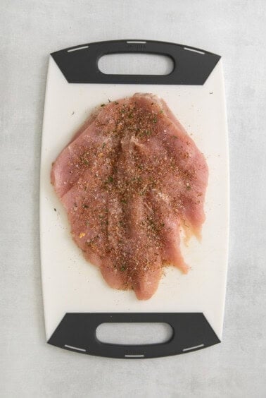 a cutting board with a piece of meat on it.