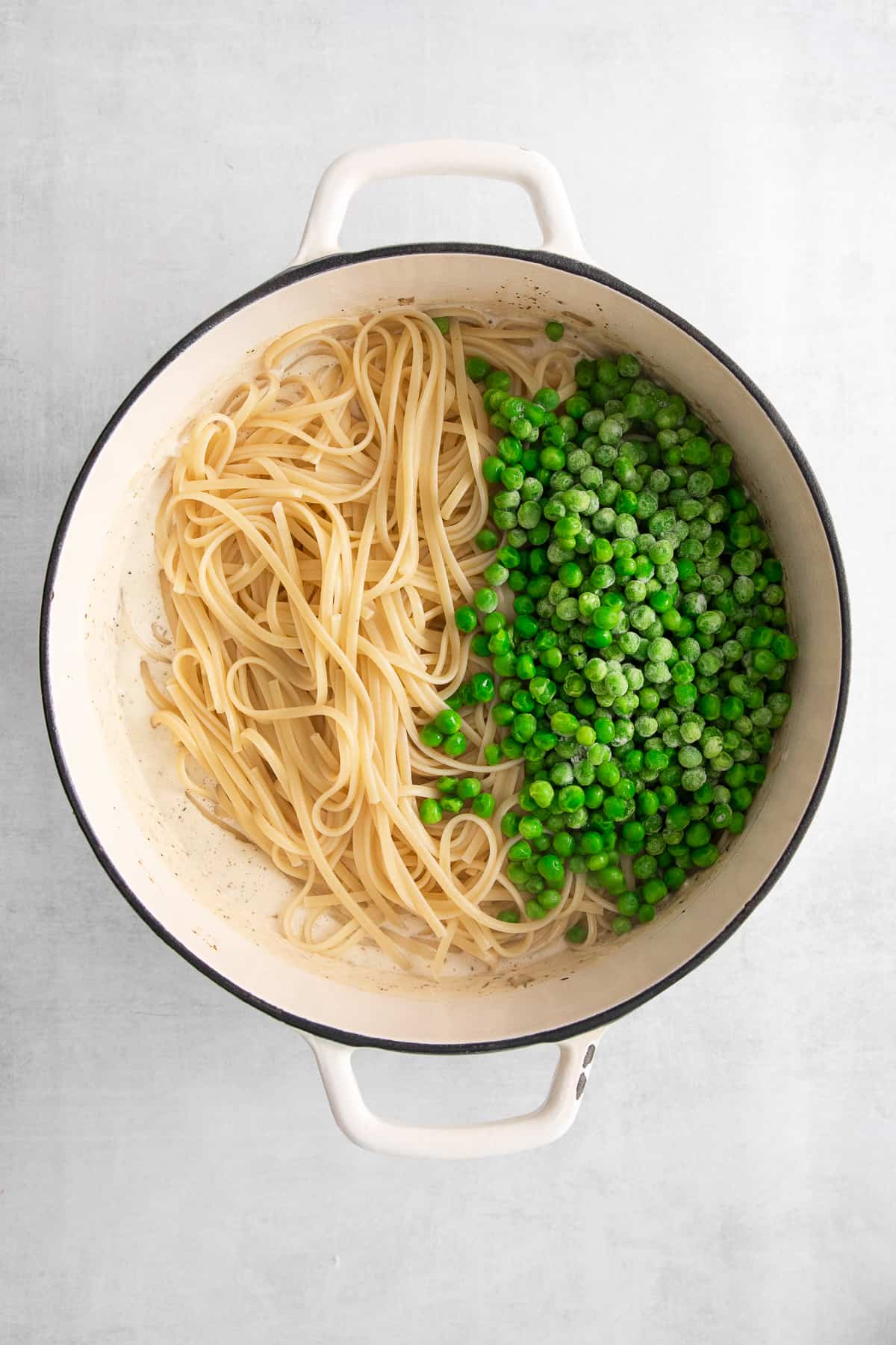 adding peas and noodles to pot.