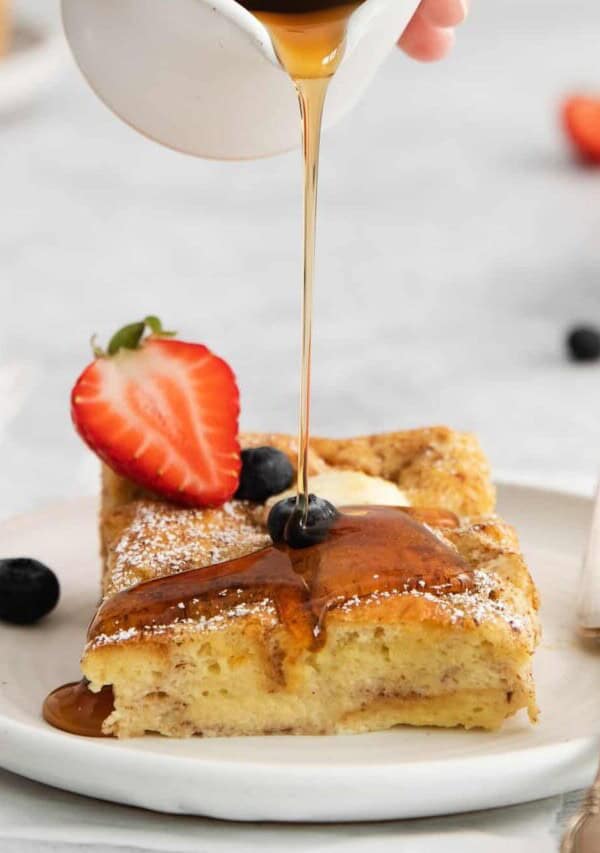 cream cheese french toast bake with syrup being poured on top