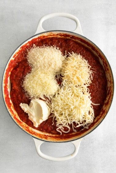 a pan with sauce and cheese in it.