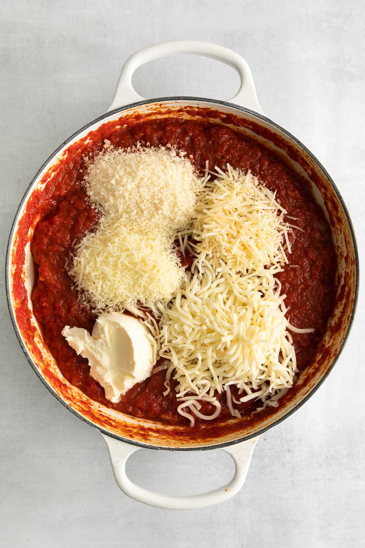 Marinara sauce with 5 varieties of cheese on top of it.