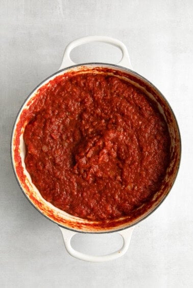 red sauce in a pan on a white surface.