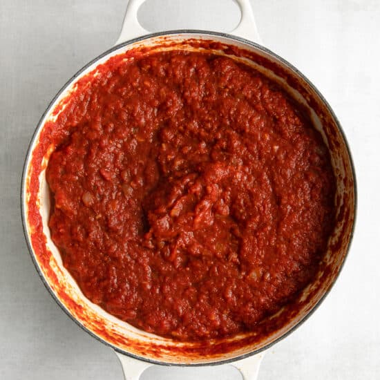 red sauce in a pan on a white surface.