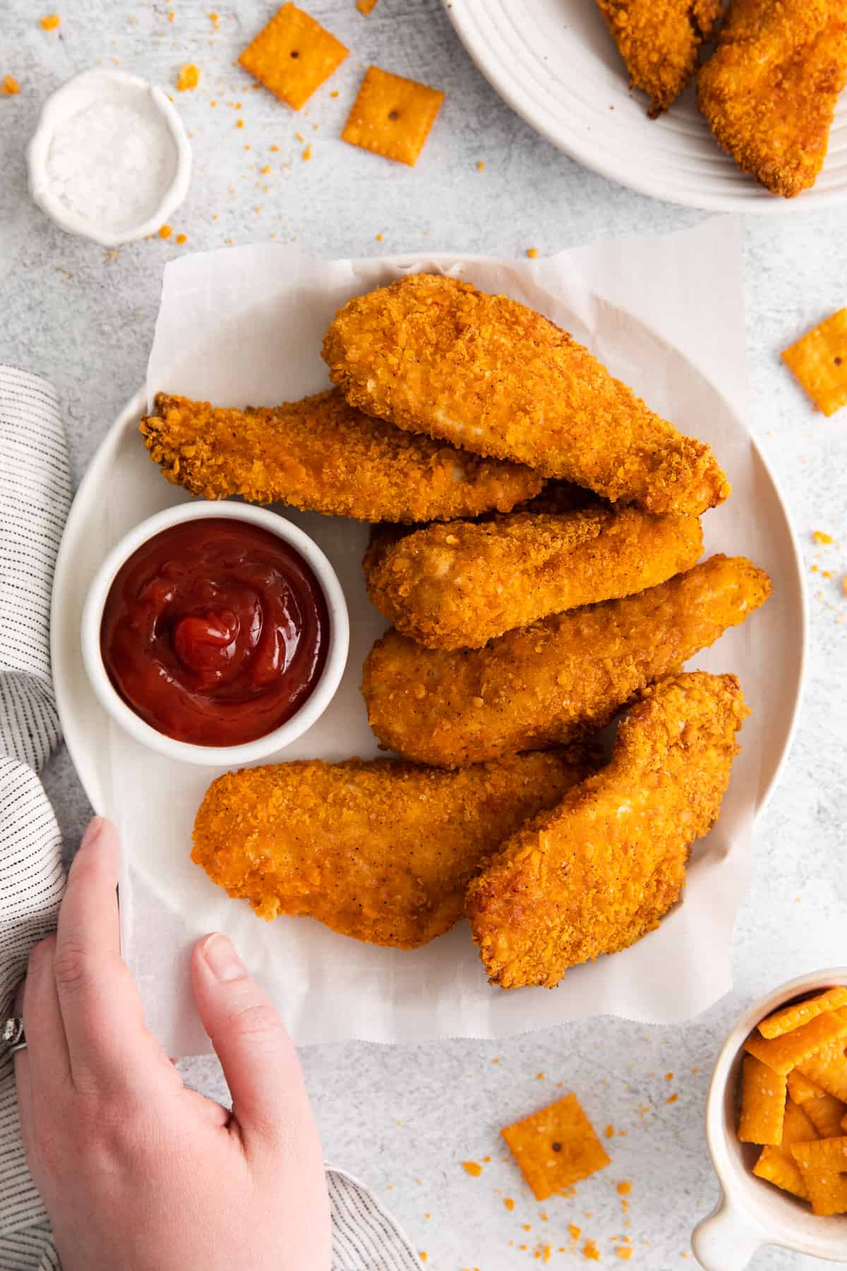 Chicken fingers on a plate with ketchup.