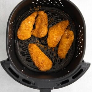 fried chicken in an air fryer on a white background.