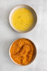 two bowls with two different types of seasonings next to each other.